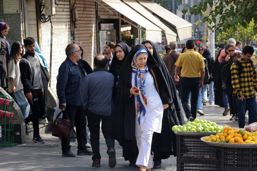 Aparência de normalidade:  Pessoas caminham numa rua de Teerã; comércio funcionou normalmente, após madrugada de bombardeios