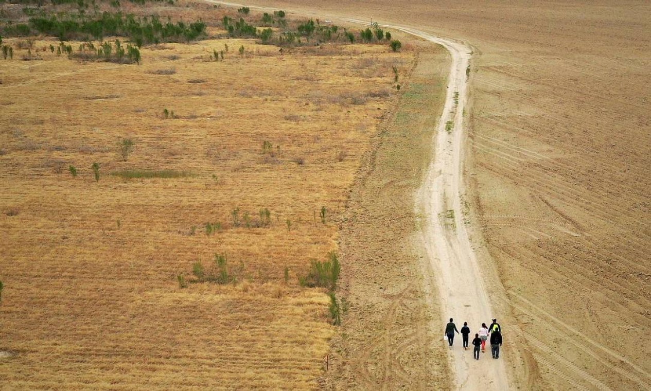 Famílias de imigrantes em busca de asilo de Honduras e Guatemala caminham por uma estrada de terra depois de cruzar ilegalmente o Rio Grande para os EUA vindo do México, em Penitas, Texas  — Foto: Adrees Latif / REUTERS - 10/01/2019