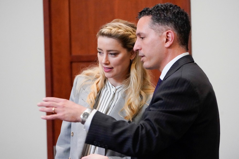 Amber Heard conversa com um de seus advogados, Benjamin Rottenborn, no Tribunal do Condado de Fairfax, na Virgínia, EUA, em 27 de maio de 2022 — Foto: Steve Helber / AFP