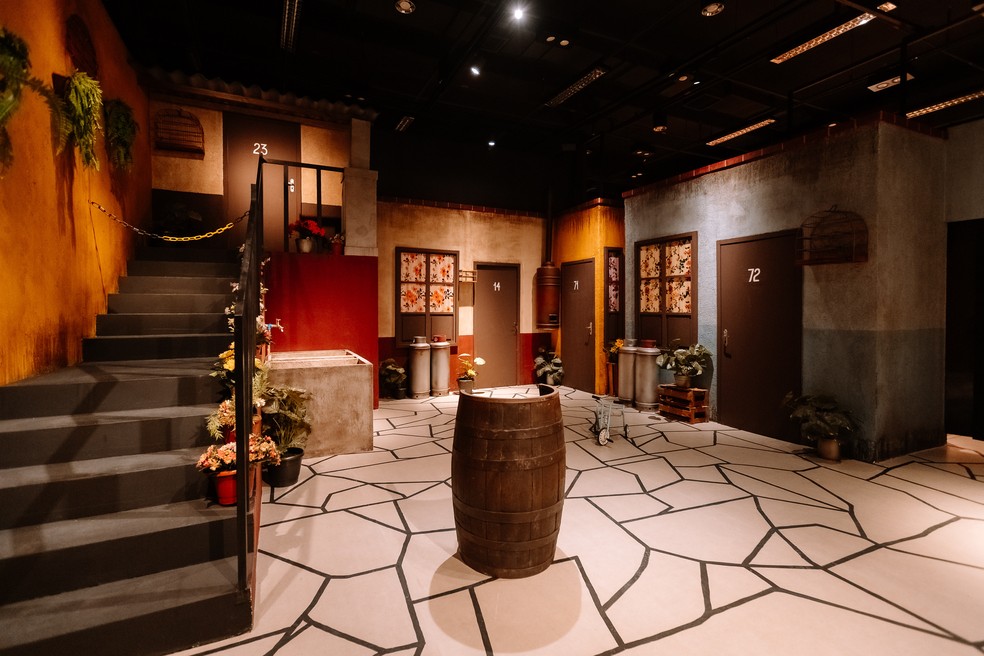 O icônico pátio da Vila do Chaves, com o barril e detalhes originais, transporta os visitantes para dentro do seriado — Foto: Divulgação