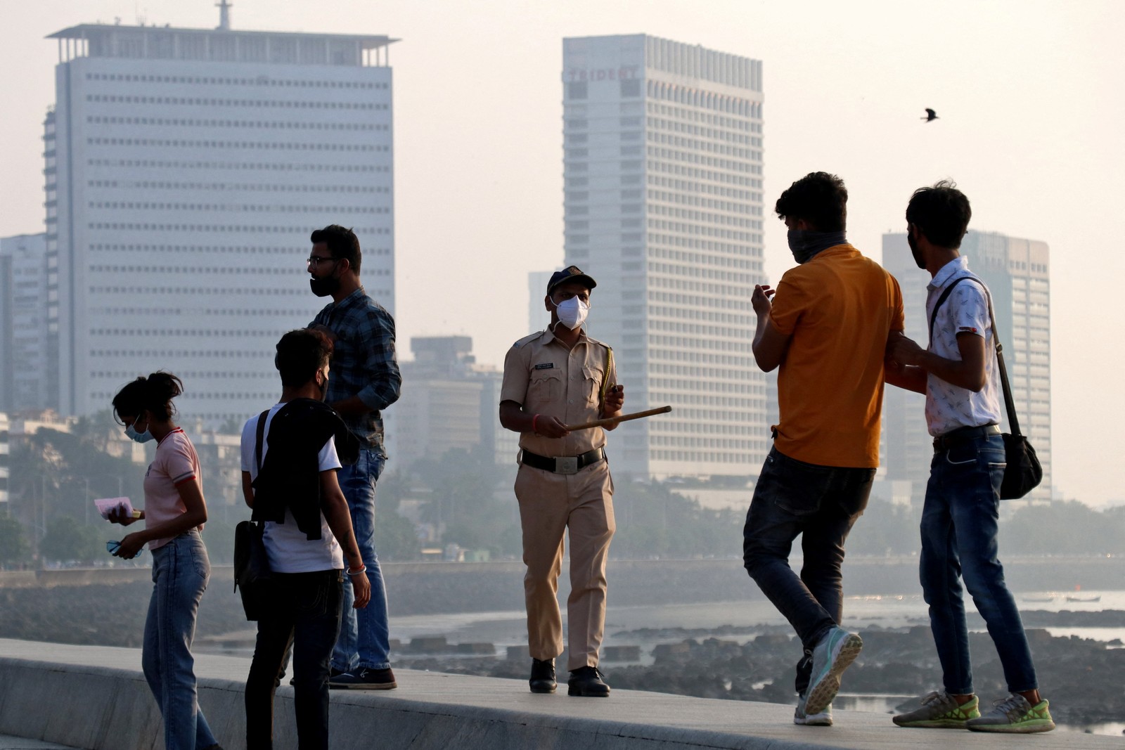 Policial pede às pessoas que saiam do passeio na unidade da Marinha, durante restrições para limitar as reuniões públicas em meio à disseminação do coronavírus em MumbaiREUTERS