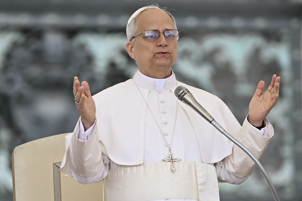 O Papa Leão XIV discursa para a multidão durante sua primeira audiência geral semanal na Praça de São Pedro — Foto: Filippo MONTEFORTE / AFP