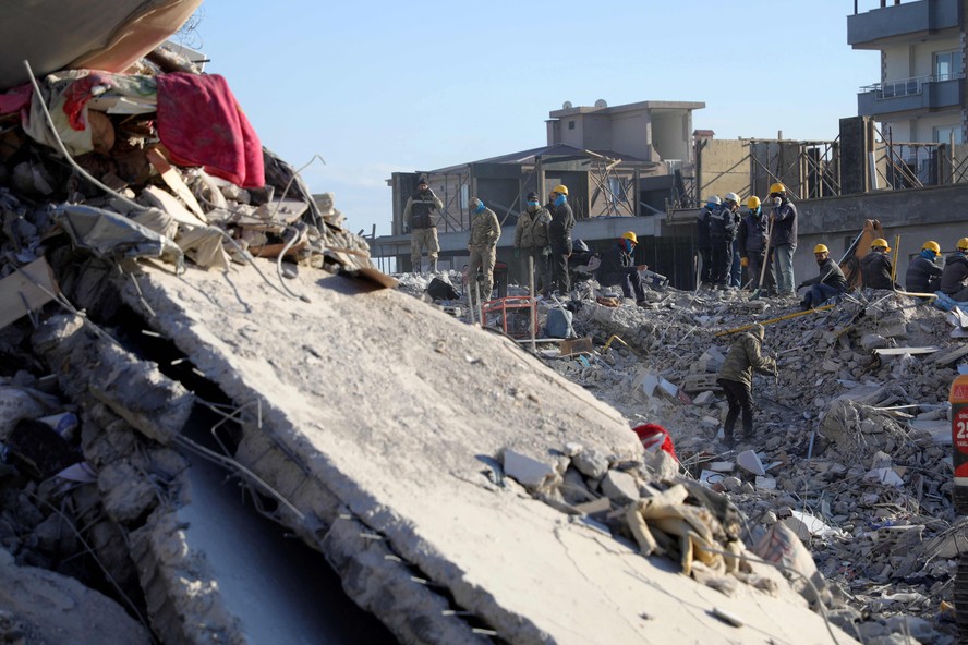 Equipes de resgate vasculham os escombros de edifícios desabados em Nurdagi, na Turquia, em 13 de fevereiro de 2023
