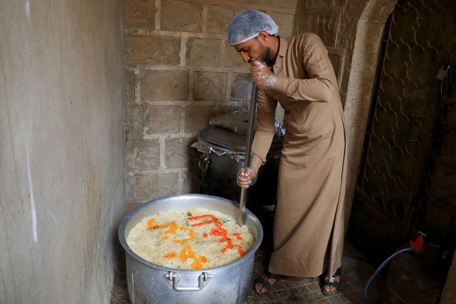 Voluntário iemenita prepara comida para ser distribuída gratuitamente, na capital Sanaã, para a refeição "Iftar" do jejum do Ramadã — Foto: MOHAMMED HUWAIS/AFP