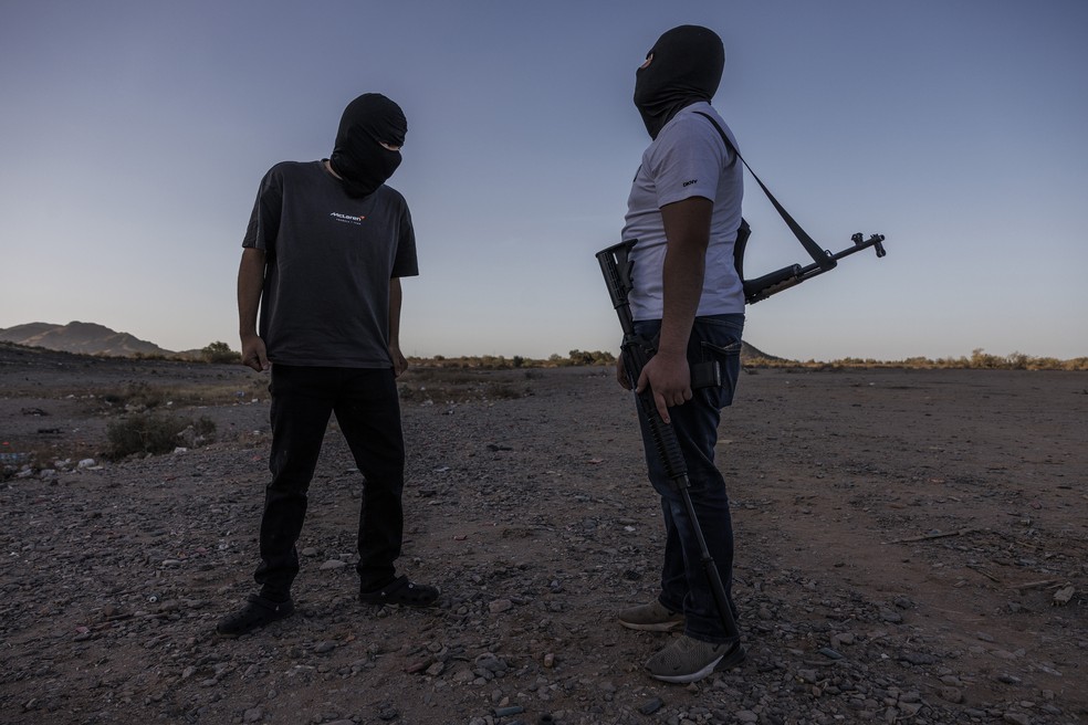 Traficantes de armas americanos conhecidos como El Flaco (à esq.) e Chuy em deserto nos arredores de Phoenix, nos EUA — Foto: Adriana Zehbrauskas/The New York Times