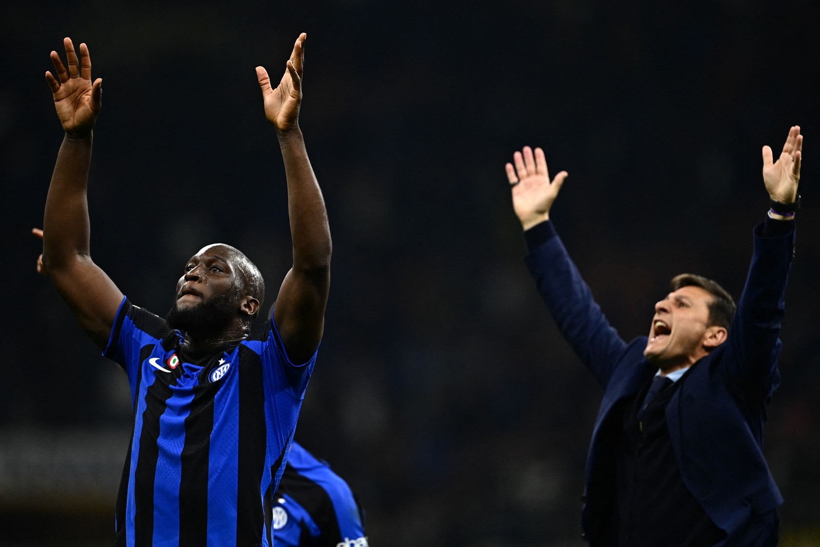 O atacante belga Romelu Lukaku e o vice-presidente da Inter de Milão, Javier Zanetti, cumprimentam o público após a vitória do time na semifinal da Champions League — Foto: GABRIEL BOUYS / AFP