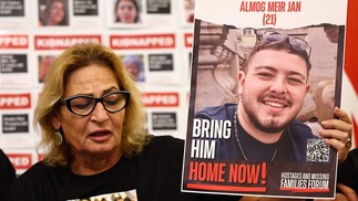 Orit Meir, mãe de Almog Meir, de 21 anos, mantido refém pelo grupo Hamas em Gaza, segura uma foto de seu filho durante uma entrevista coletiva na embaixada de Israel em Londres em 20 de novembro de 2023 — Foto: HENRY NICHOLLS / AFP