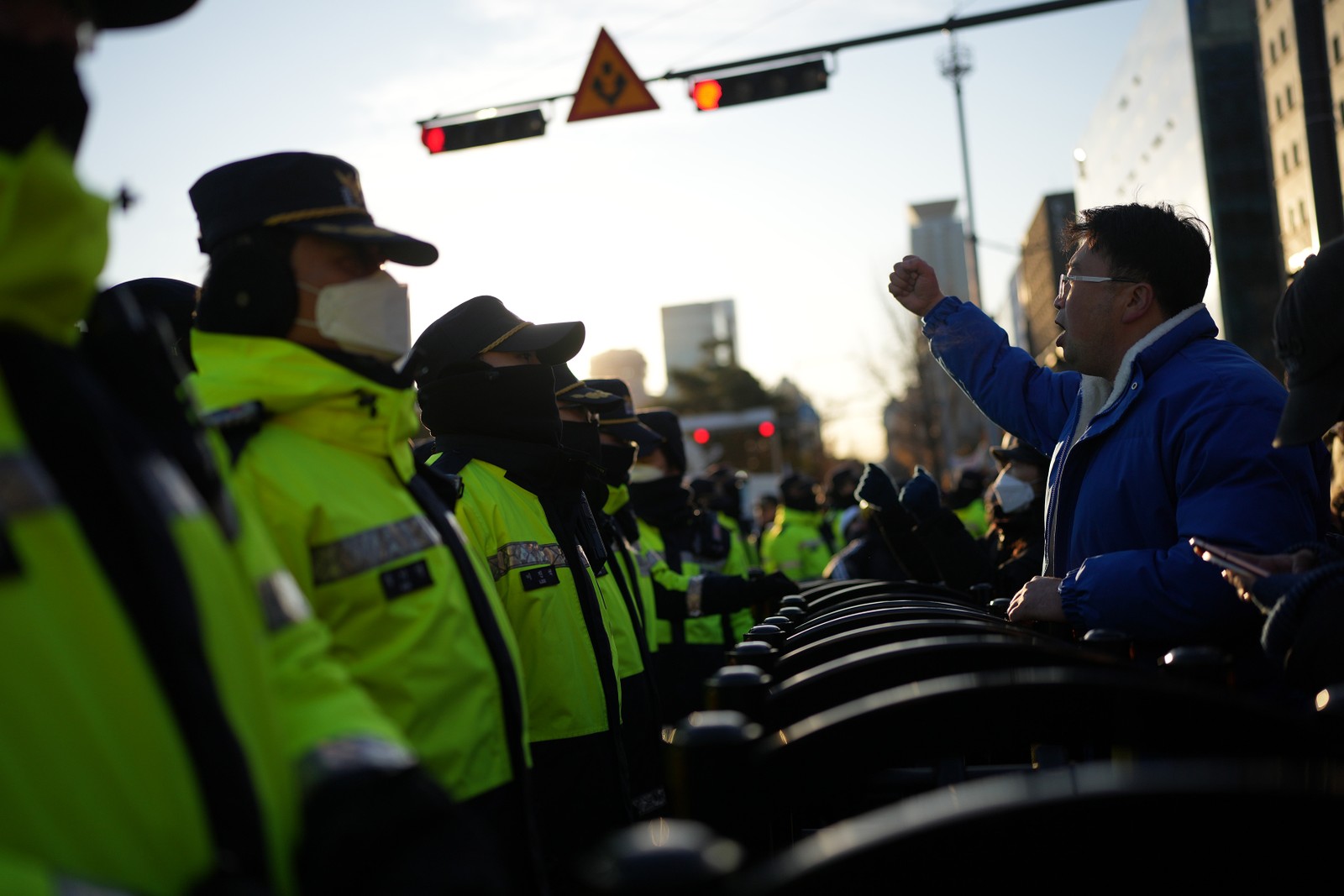 Policiais fazem guarda na Praça Gwanghwamun, em Seul, enquanto manifestantes pedem a destituição de Yoon Suk-yeol, após a breve imposição da lei marcial — Foto: Chang W. Lee/The New York Times