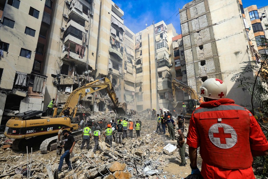 Equipes de resgate buscam desaparecidos sob os escombros de prédios derrubados por ataque israelense contra o Hezbollah em BeiruteBw