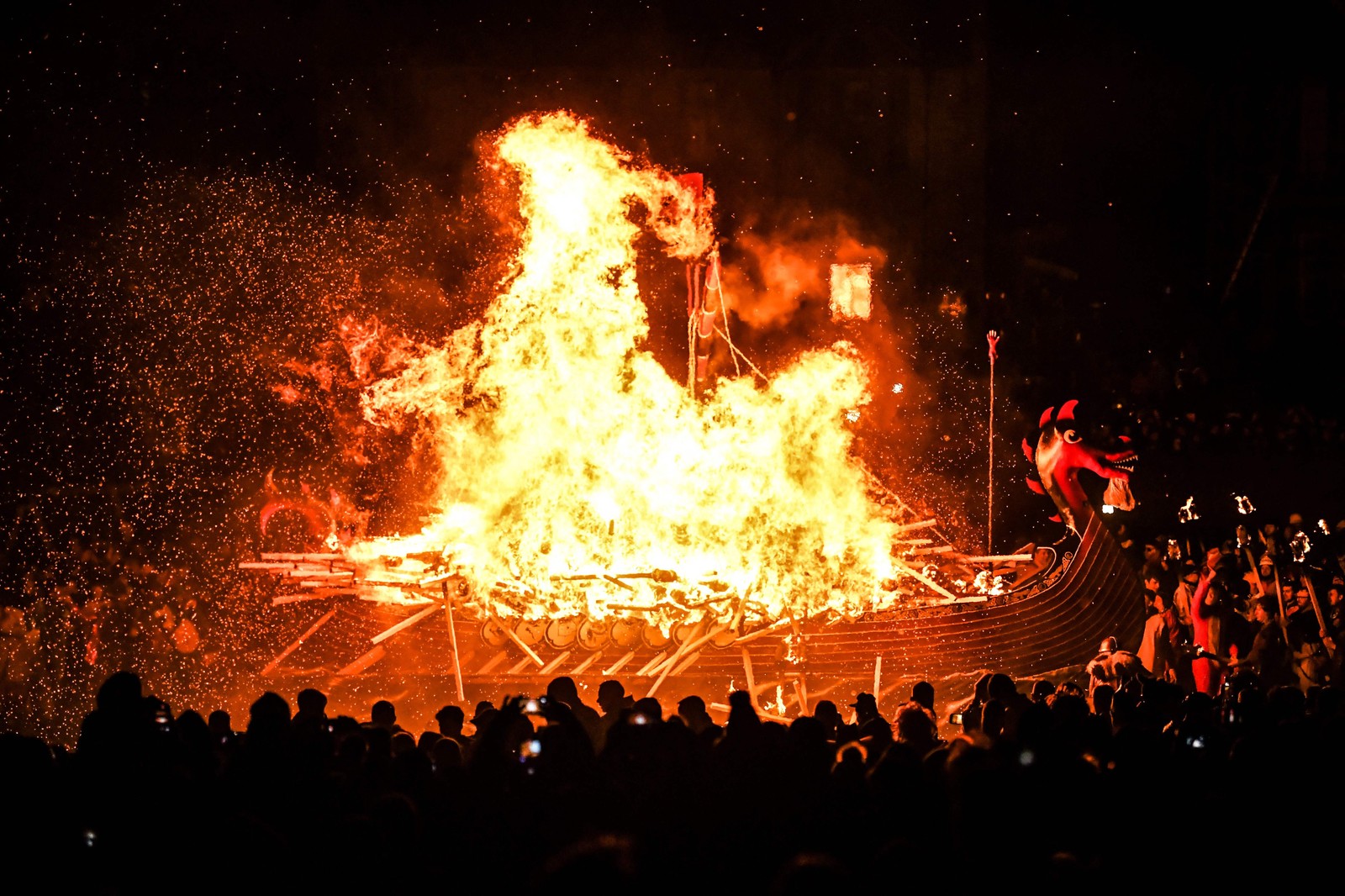 As procissões iluminadas por tochas e a queima de escaleres são um eco dos rituais nórdicos pagãos — Foto: Andy Buchanan / AFP