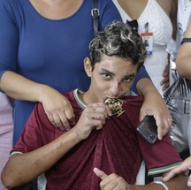 Com sonho de se tornar jogador de futebol, Christhian beija o escudo do Vasco na saída do hospital — Foto: Roberto Moreyra / Agência O Globo
