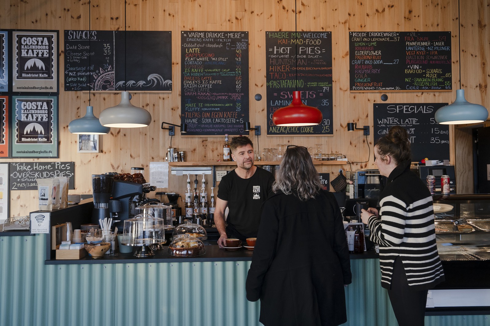 Shaun Gamble E OS Caperes DoCafé Costa Kalundborg Kaffe, Com Vista para o porto em Kalundborg - Foto: Charlotte de la Foot/The New York Times