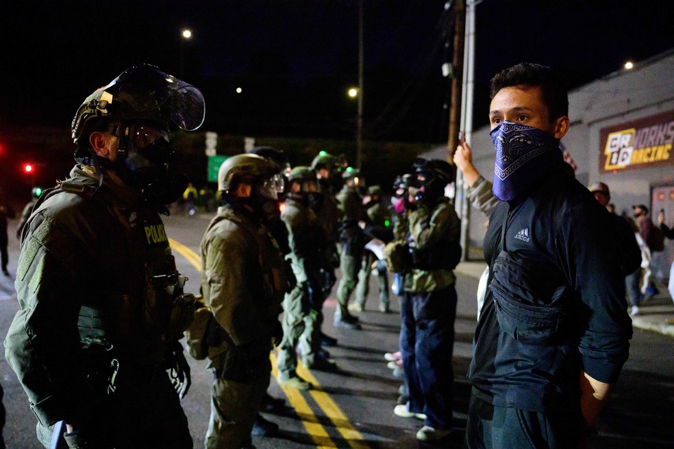 Agentes federais dos EUA impedem a aproximação de manifestantes diante de prédio da imigração em Portland, no estado do Oregon — Foto: Mathieu Lewis-Rolland / AFP