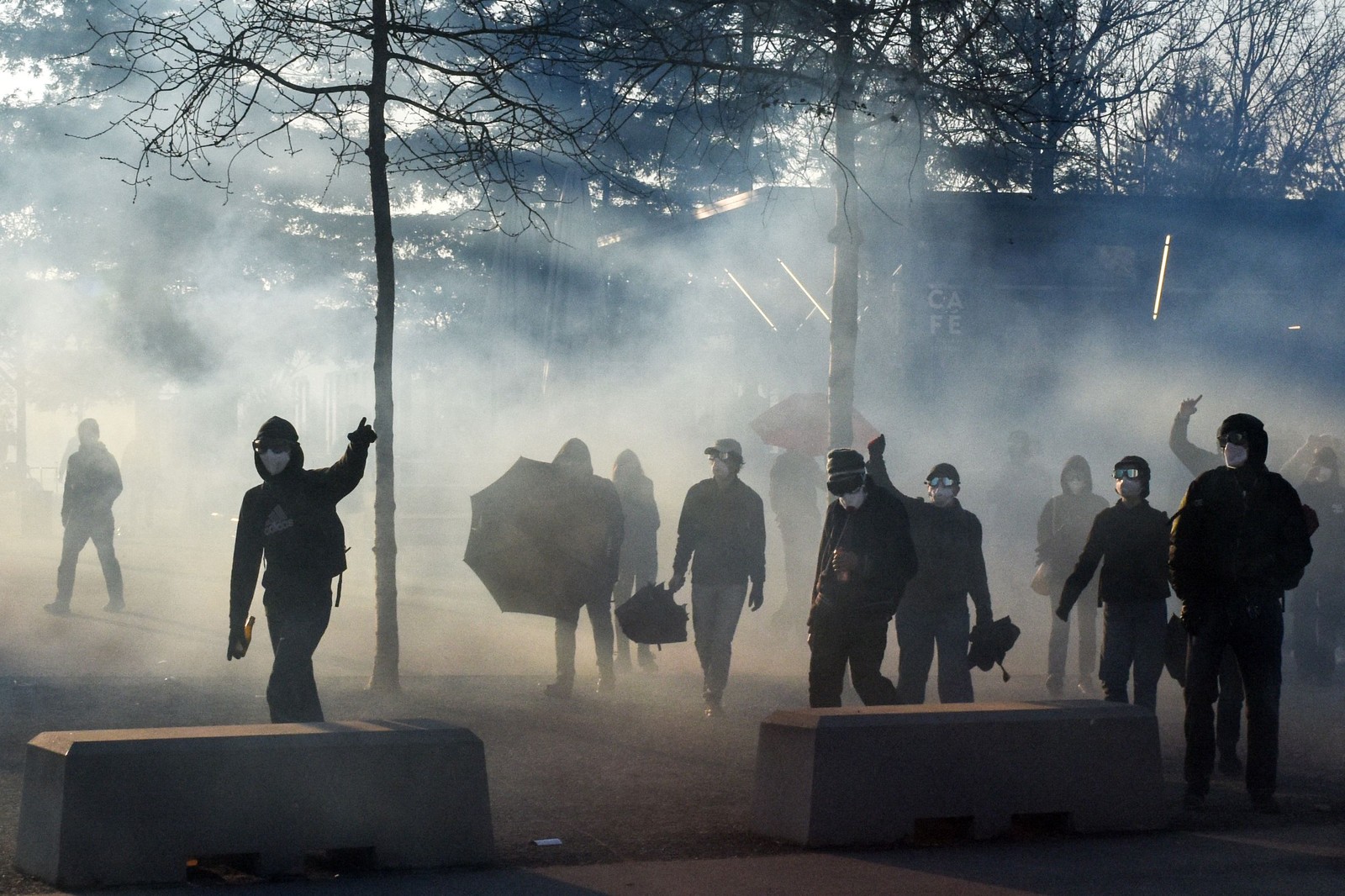 Manifestantes gritam palavras de ordem em meio à fumaça de gás lacrimogêneo durante confrontos na manifestação — Foto: Sebastien Salom-Gomis/AFP