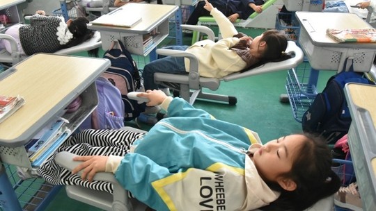 Na China, estudantes usam  mesas e cadeiras dobráveis ​​para tirar uma soneca nos intervalos; entenda