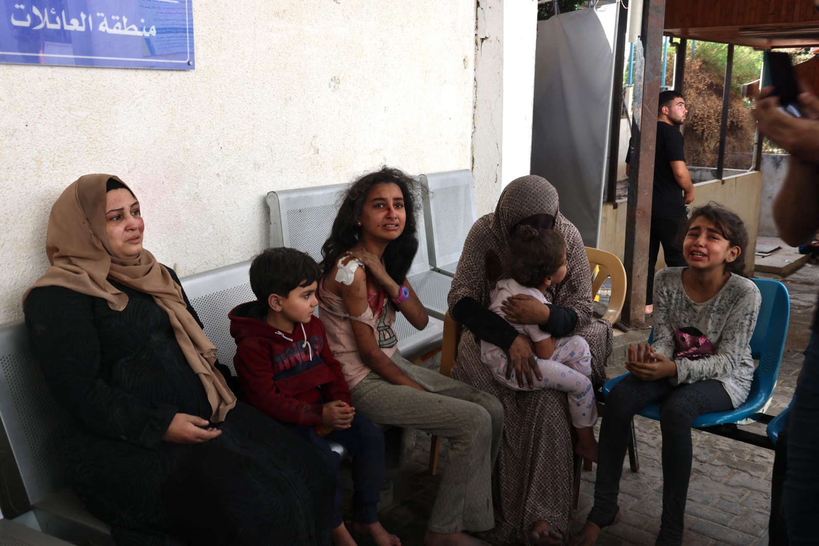 Família palestina espera por atendimento em hospital na Faixa de Gaza — Foto: Said Khatib/AFP