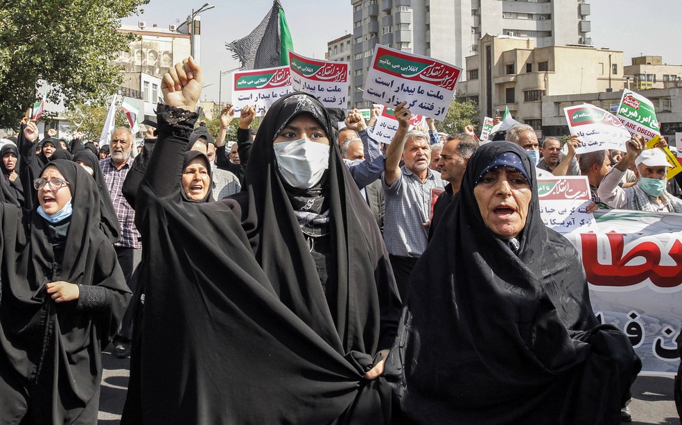Mulheres e homens cantam slogans enquanto marcham em uma manifestação pró-hijab na capital do Irã, Teerã, em 23 de setembro de 2022. — Foto: AFP