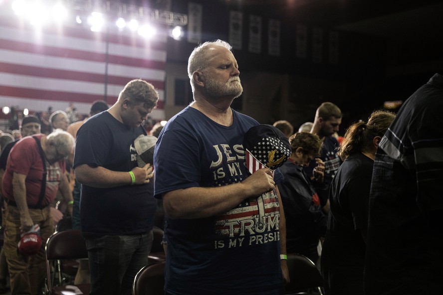 Apoiadores do ex-presidente Donald Trump rezam em um comício de campanha em Erie, Pensilvânia