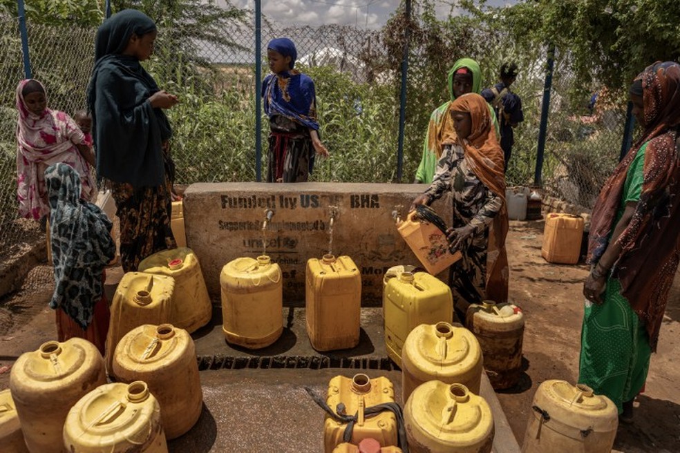 Pessoas coletam água em uma torneira comunitária em um acampamento para deslocados pela violência e pela seca, em Dollow, na Somália, em 28 de abril de 2026 — Foto: Finbarr O'Reilly/The New York Times