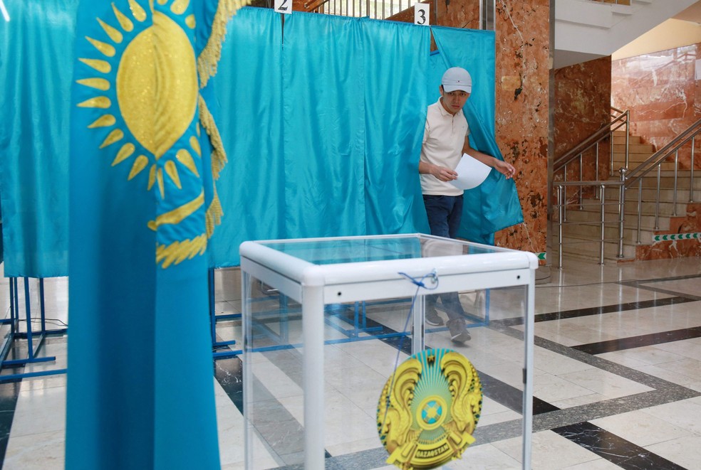 Eleitor sai da cabine para depositar seu voto no referendo sobre mudanças constitucionais no Cazaquistão — Foto: Ruslan Pryanikov/AFP