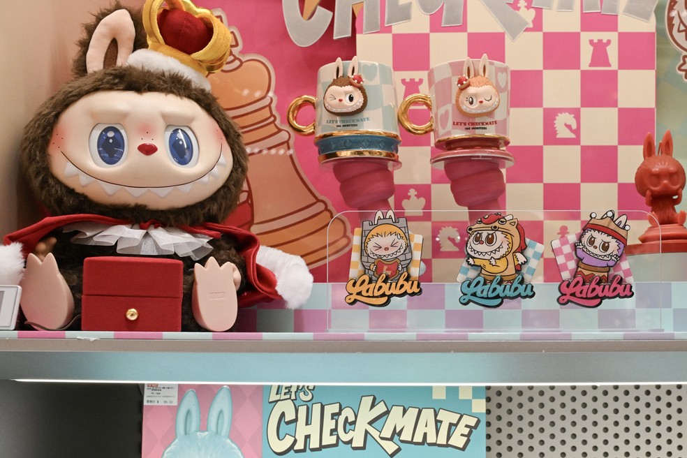 Uma boneca Labubu “não disponível para venda” (à esquerda) e adesivos da Labubu são vistos em uma loja da Pop Mart em Pequim — Foto: Adek Berry/AFP
