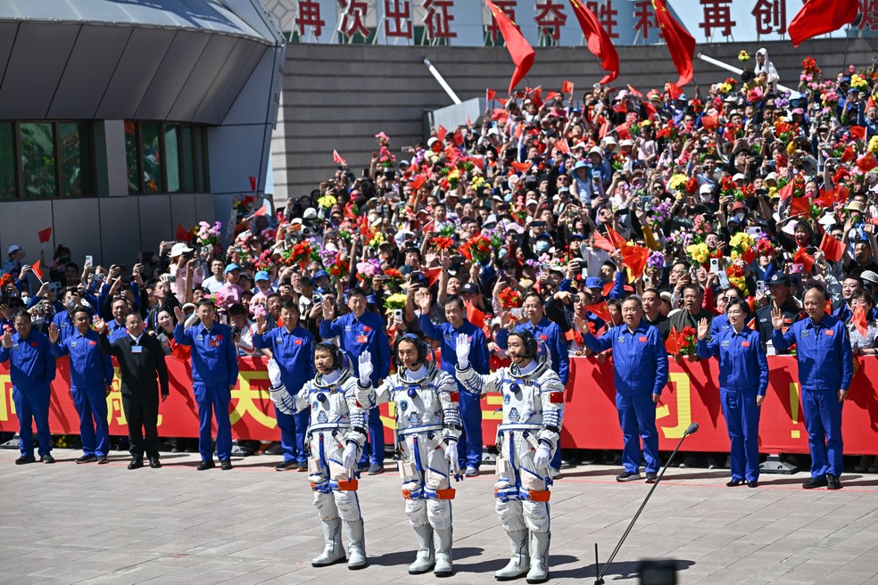 Os astronautas da missão espacial chinesa Shenzhou-20, Wang Jie, Chen Zhongrui e Chen Dong — Foto: Pedro Pardo / AFP