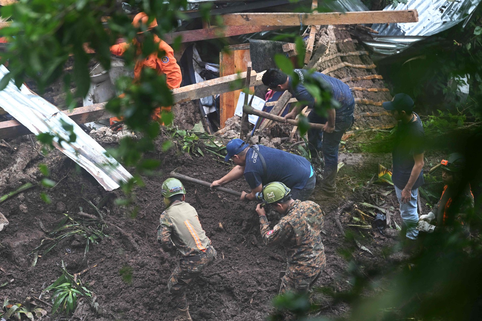Soldados e socorristas salvadorenhos tentam resgatar corpos de cinco pessoas que morreram após um deslizamento de terra em Huizucar, El Salvador — Foto: Marvin RECINOS / AFP