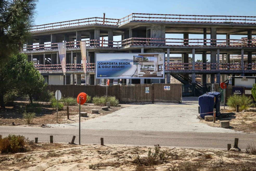 Um outdoor promove um'resort de praia e golfe' em frente a um edifício em construção na Comporta, Portugal — Foto: Patricia de Melo Moreira / AFP