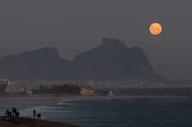 Do Mirante do Roncador, perto da Prainha, Lua nasce ao lado da Pedra da Gávea