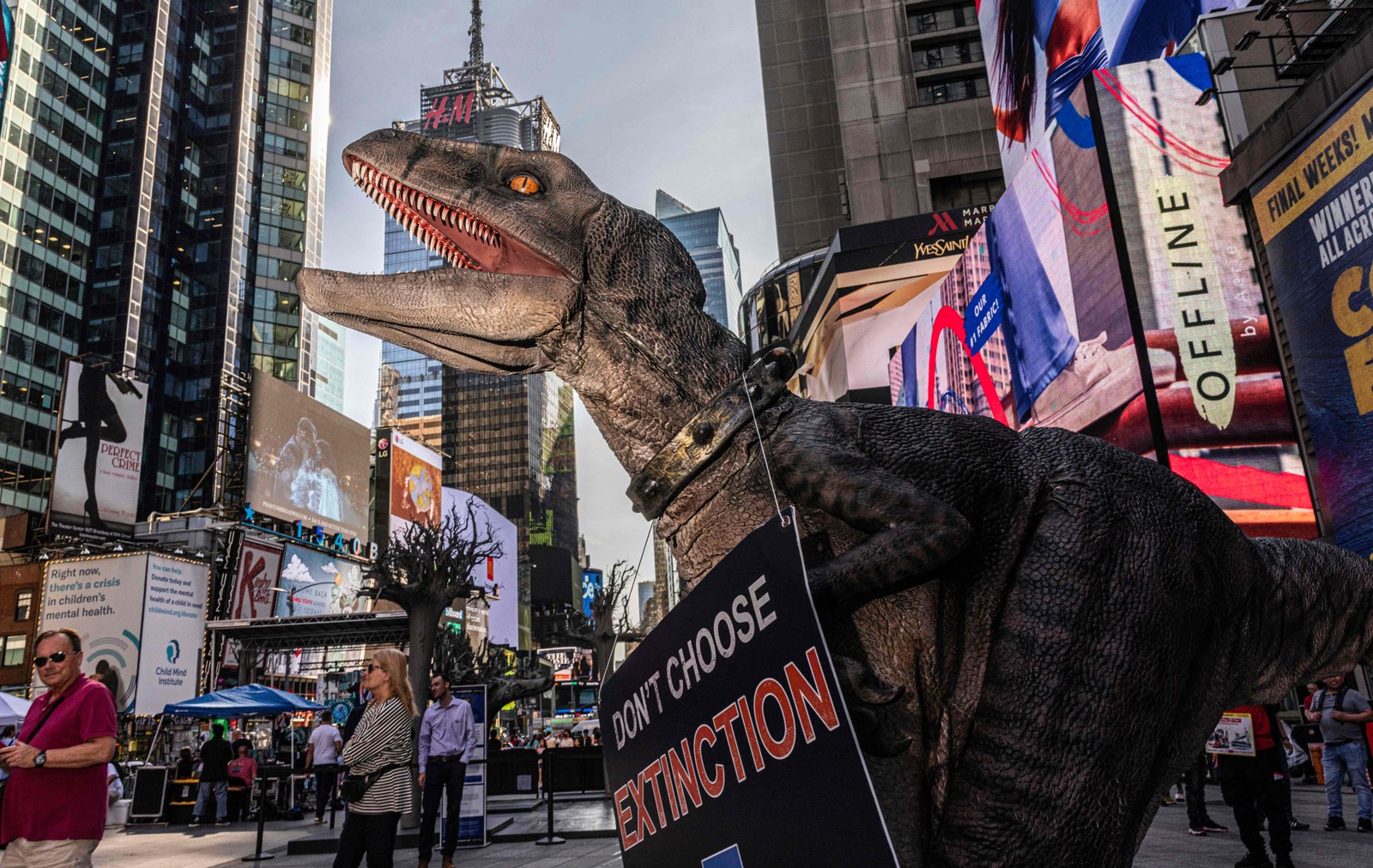 Dinossauro mascote da ONU visita a Times Square, em Nova York, para conscientizar o público sobre as mudanças climáticas. — Foto: Alex Kent / AFP