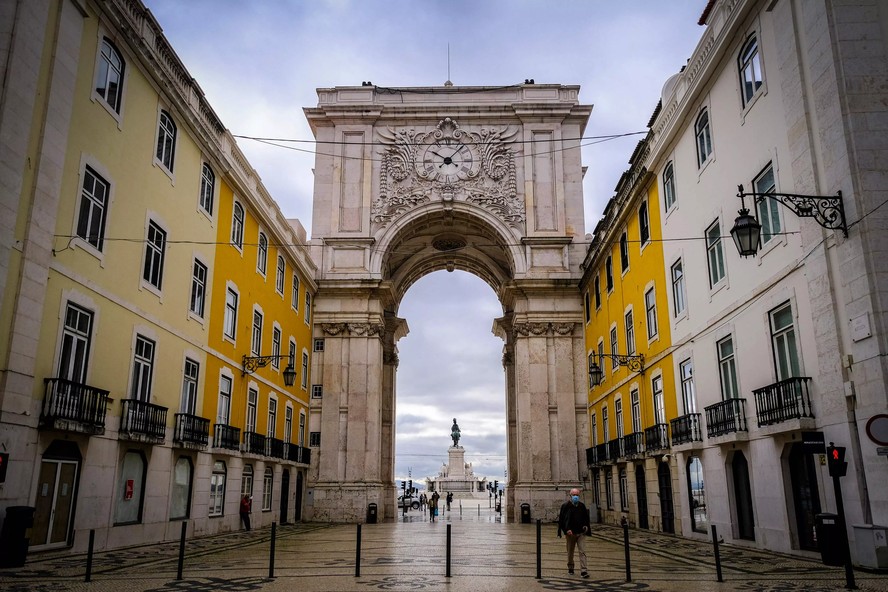 Homem caminha perto da Praça do Comércio, em Lisboa