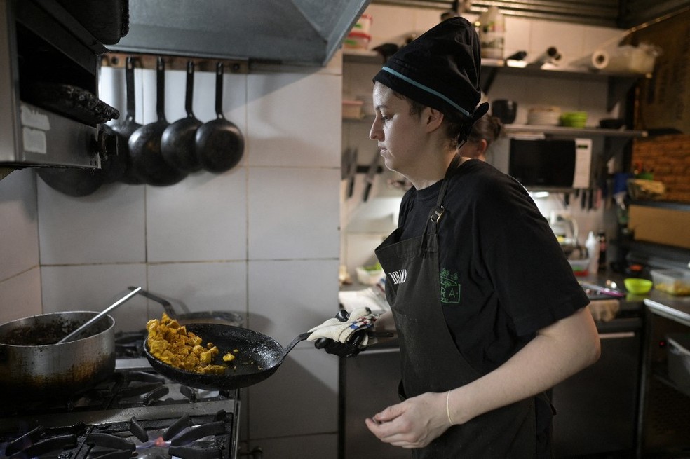 A chefe de cozinha Agustina Bovi cozinha no pequeno restaurante vegano "Yedra", onde trabalha em Buenos Aires &mdash; Foto: JUAN MABROMATA / AFP