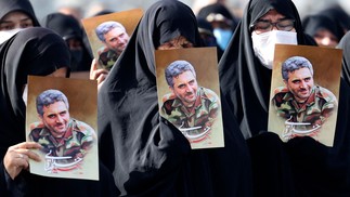 Mulheres iranianas levantam retratos do coronel Sayyad Khodai da Guarda Revolucionária durante seu cortejo fúnebre na praça Imam Hussein, na capital Teerã. Ele foi assassinado, e o Irã atribui o atentado a "elementos ligados à arrogância global" – termo da república islâmica para seu arqui-inimigo os Estados Unidos e aliados dos EUA, incluindo Israel  — Foto: ATTA KENARE / AFP