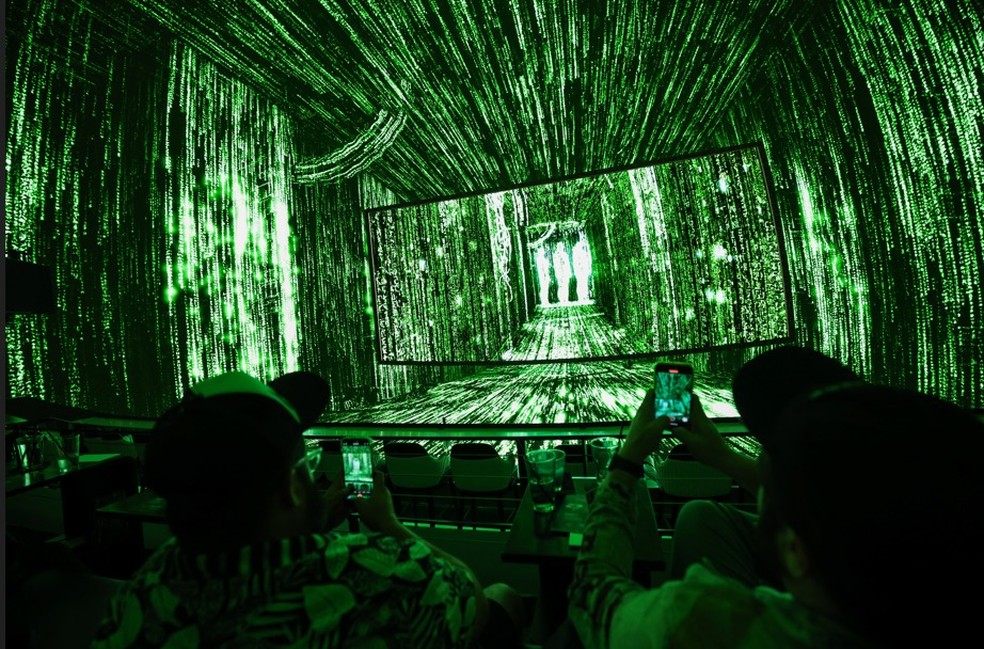Os espectadores assistem a um código de computador imersivo aparecer durante a primeira exibição de realidade compartilhada do filme "Matrix" — Foto: Patrick T. Fallon / AFP