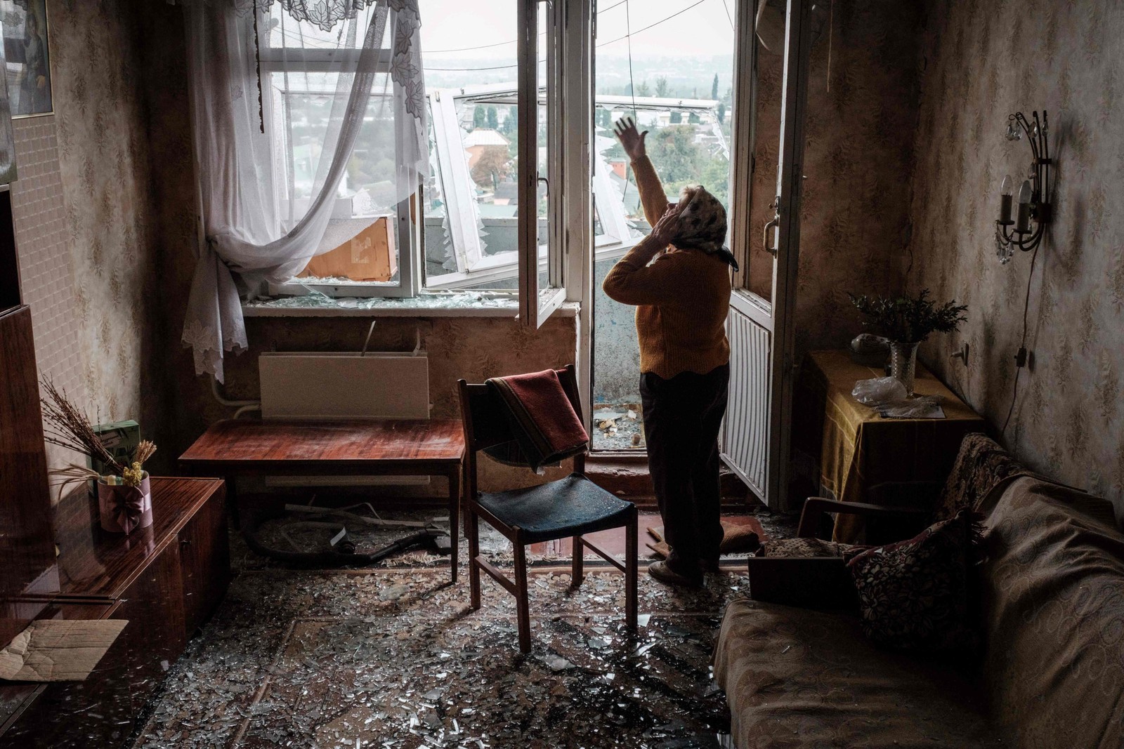 Lyubov Prokofjevna, 85 anos, fala ao telefone em seu apartamento danificado em um prédio atingido por um míssil, em Kharkiv, na Ucrânia — Foto: Yasuyoshi CHIBA / AFP