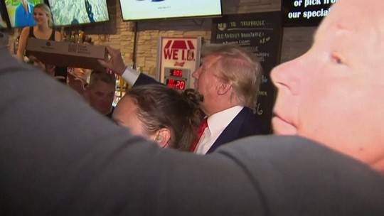 Líder nas pesquisas republicanas para eleição, Trump distribui pizza de graça em pub do 1º estado a votar; vídeo