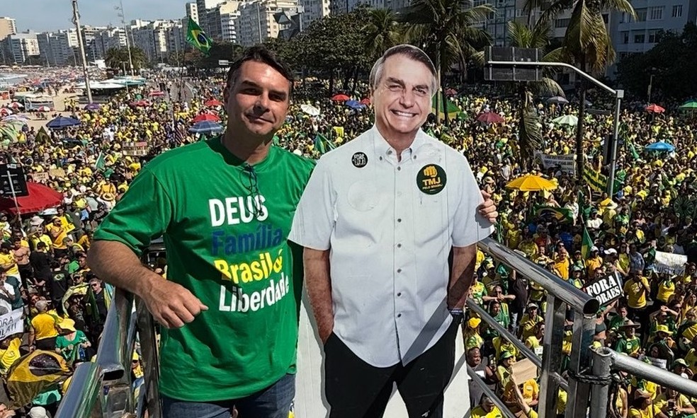 Flávio Bolsonaro com cartaz em tamanho real do pai em ato contra Moraes em Copacabana — Foto: Reprodução / X