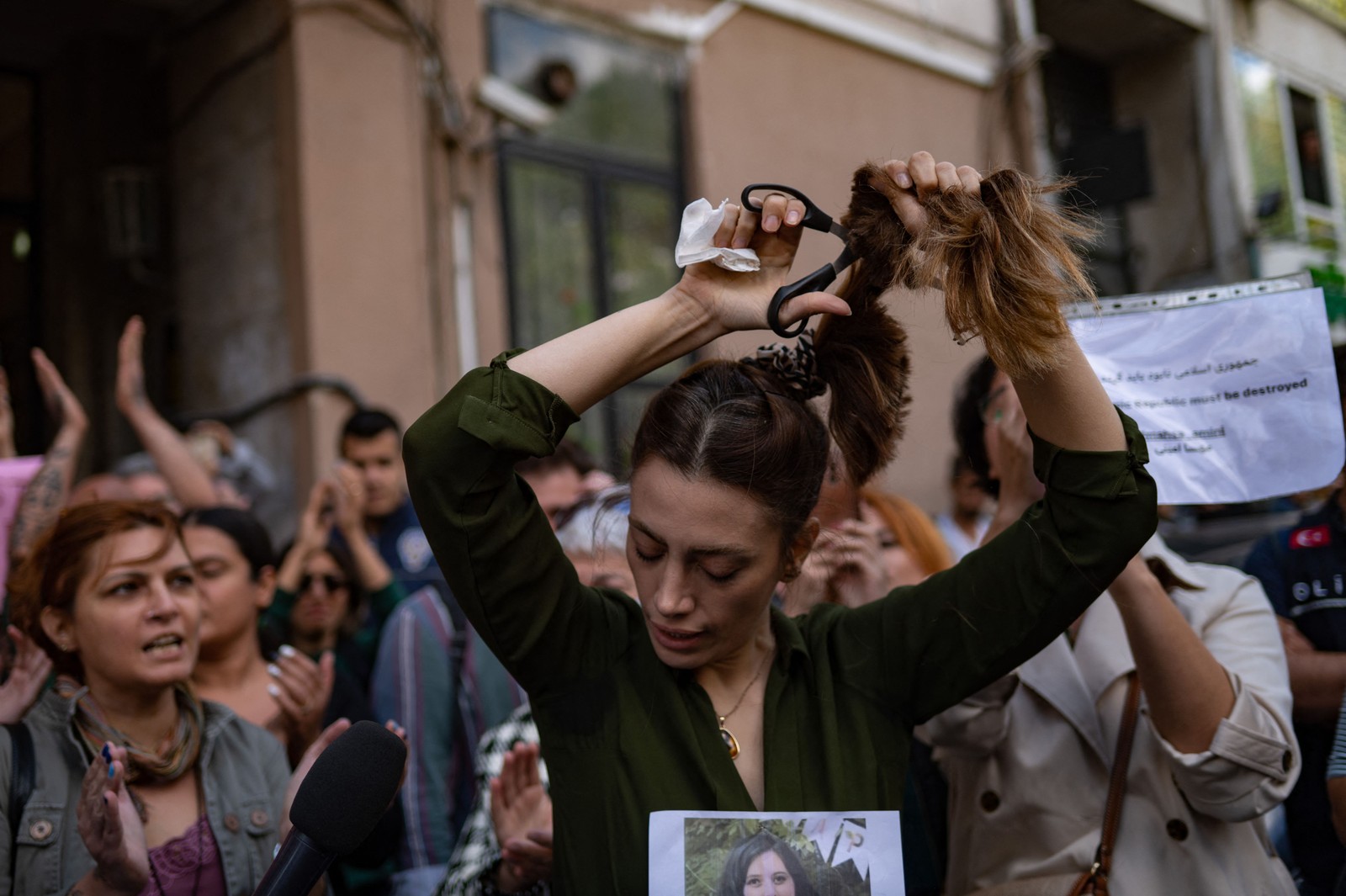 Nasibe Samsaei, uma mulher iraniana que vive na Turquia, corta seu cabelo em protesto do lado de fora do consulado iraniano, em Istambul, em 21 de setembro, após a prisão e morte de uma jovem iraniana pela polícia de moralidade em Teerã. — Foto: Yasin AKGUL / AFP