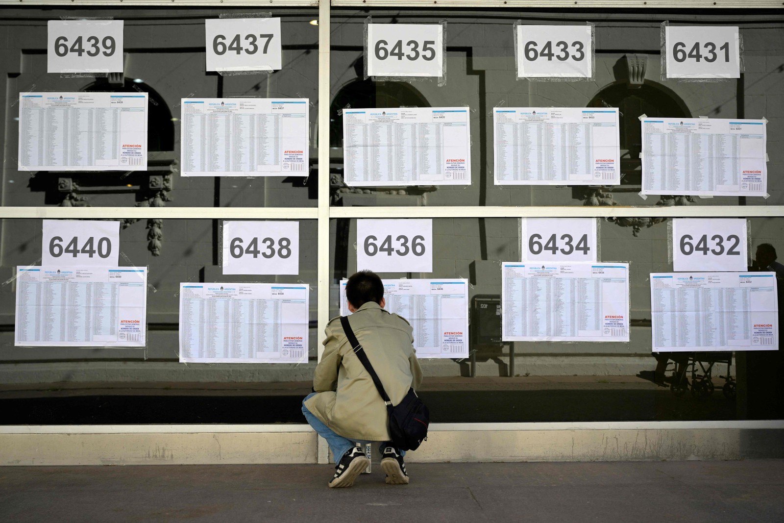 Um homem verifica os cadernos eleitorais em uma seção eleitoral em Buenos Aires — Foto: JUAN MABROMATA / AFP