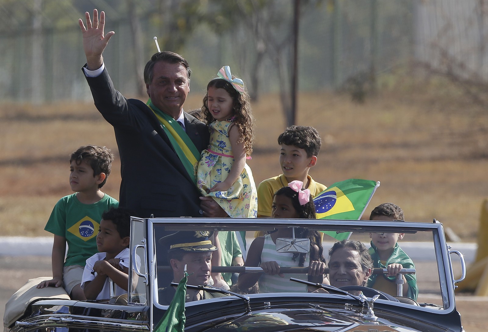 Presidente Jair Bolsonaro durante cerimônia de hasteamento da Bandeira em setembro de 2021; Nelson Piquet, piloto de F1 dirige o carro presidencial. — Foto: Cristiano Mariz / O Globo
