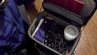 Padre, exorcista pelo Vicariato Episcopal de Campo Grande, mostra uma pequena maleta com objetos utilizados no ritual de exorcismo — Foto: Marina Calderon