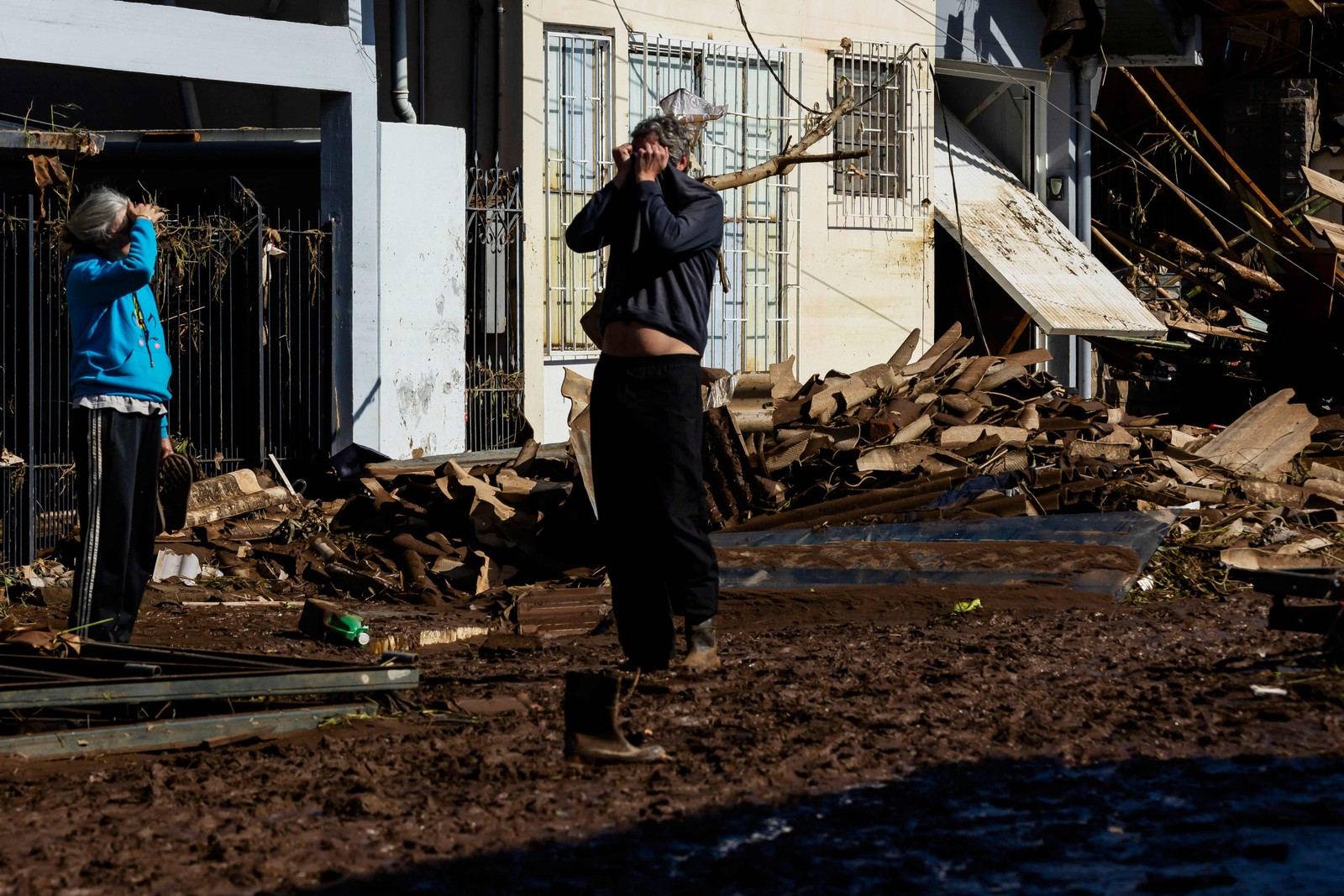 Um morador chora ao ver os estragos em sua casa em uma rua coberta de lama e detritos após passagem de um ciclone em Muçum, Rio Grande do Sul — Foto: SILVIO ÁVILA/AFP