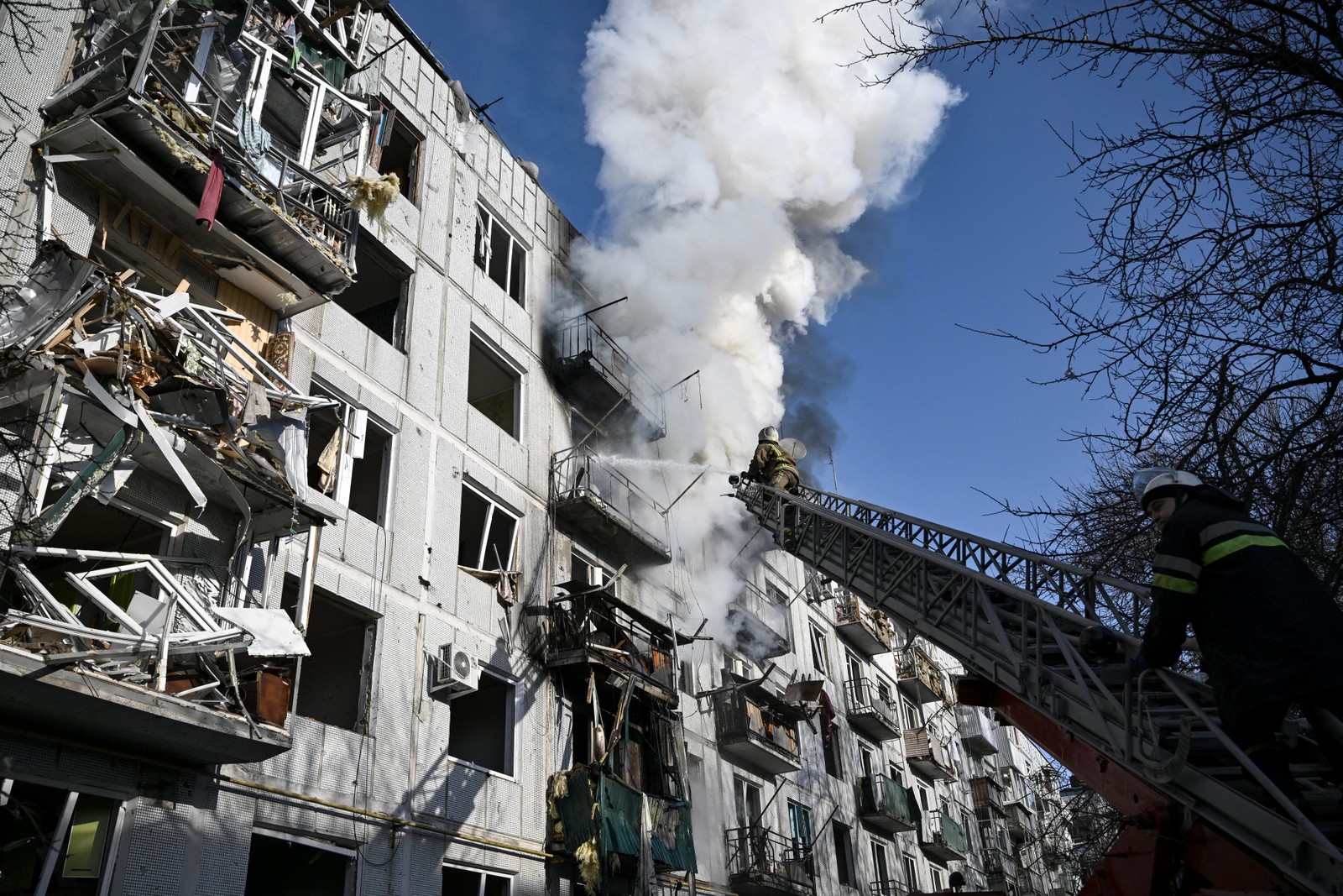 O começo: foto tirada em 24 de fevereiro de 2022 mostra bombeiros controlando um incêndio em um prédio após bombardeios na cidade de Chuguiv, no leste da Ucrânia — Foto: Aris Messinis / AFP