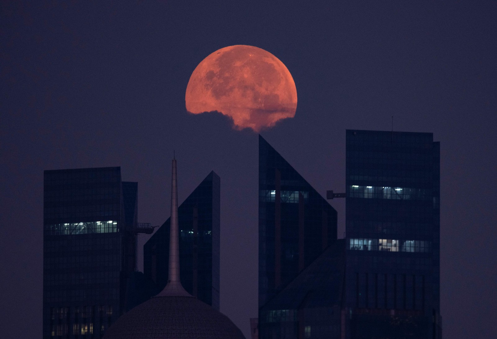 Lua cheia se põe atrás atrás dos arranha-céus de Doha, Catar — Foto: MARIANA SUAREZ/AFP
