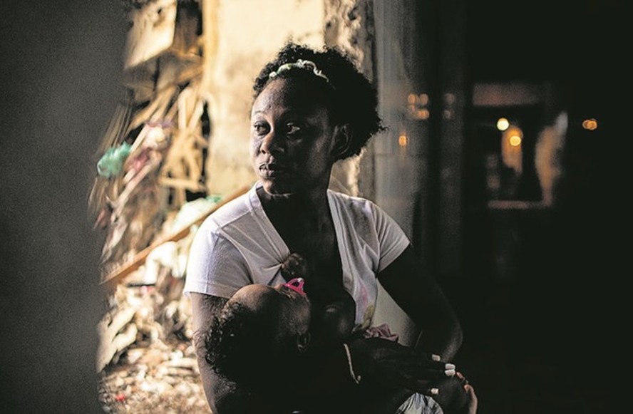 Vida em ocupação precária. Jeniffer Cristina segura a filha de 5 meses no colo em um prédio abandonado na Mangueira, que foi transformado em moradia por pessoas sem um teto: “Durmo preocupada”