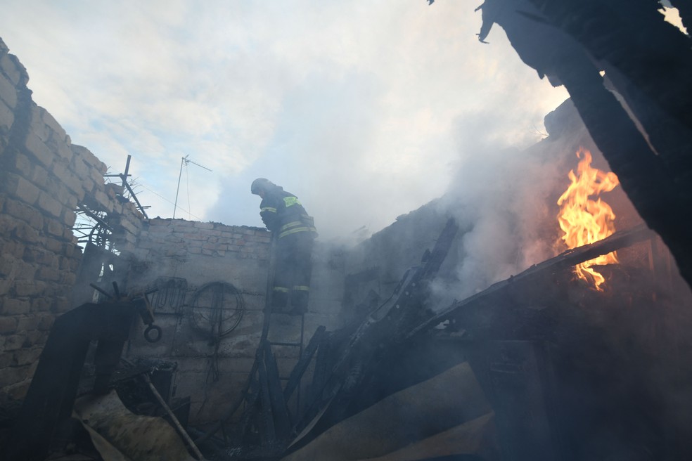 Bombeiros trabalham em um prédio atingido por bombardeio russo em uma área residencial em Donetsk, na Ucrânia — Foto: STRINGER/AFP