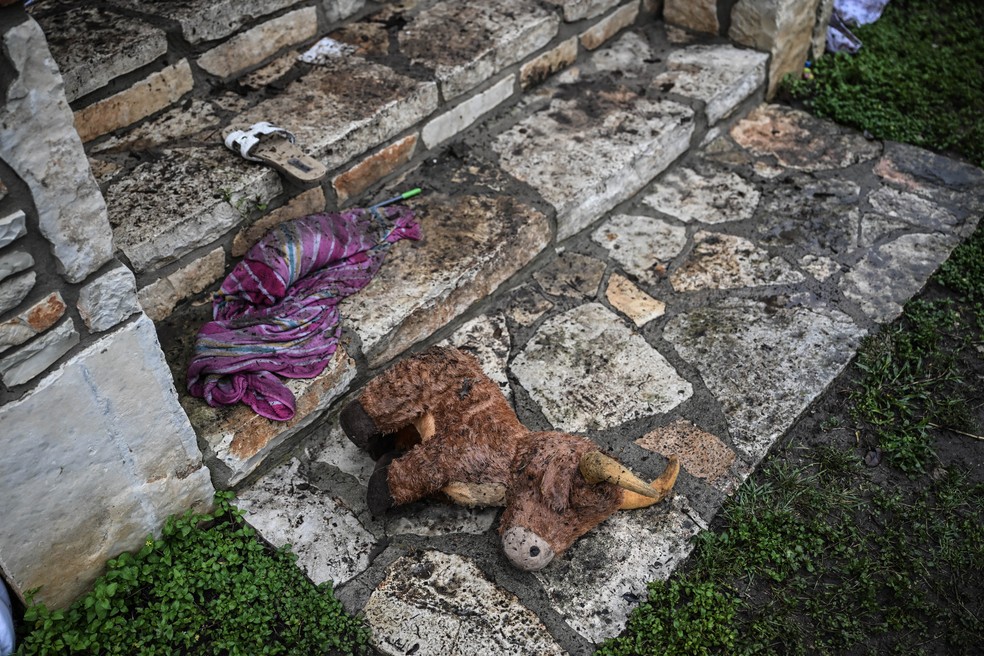 Um brinquedo de pelúcia está no chão do lado de fora de uma cabana no Acampamento Mystic — Foto: RONALDO SCHEMIDT / AFP