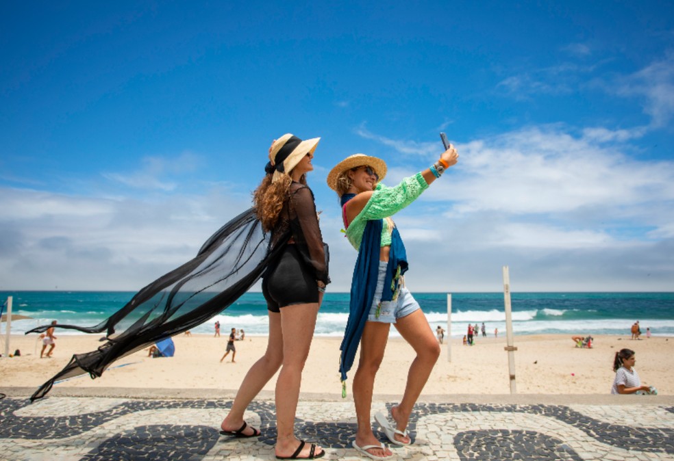 Turistas fazem selfie na Praia de Ipanema: setor é um dos pilares da economia do Rio — Foto: Ana Branco