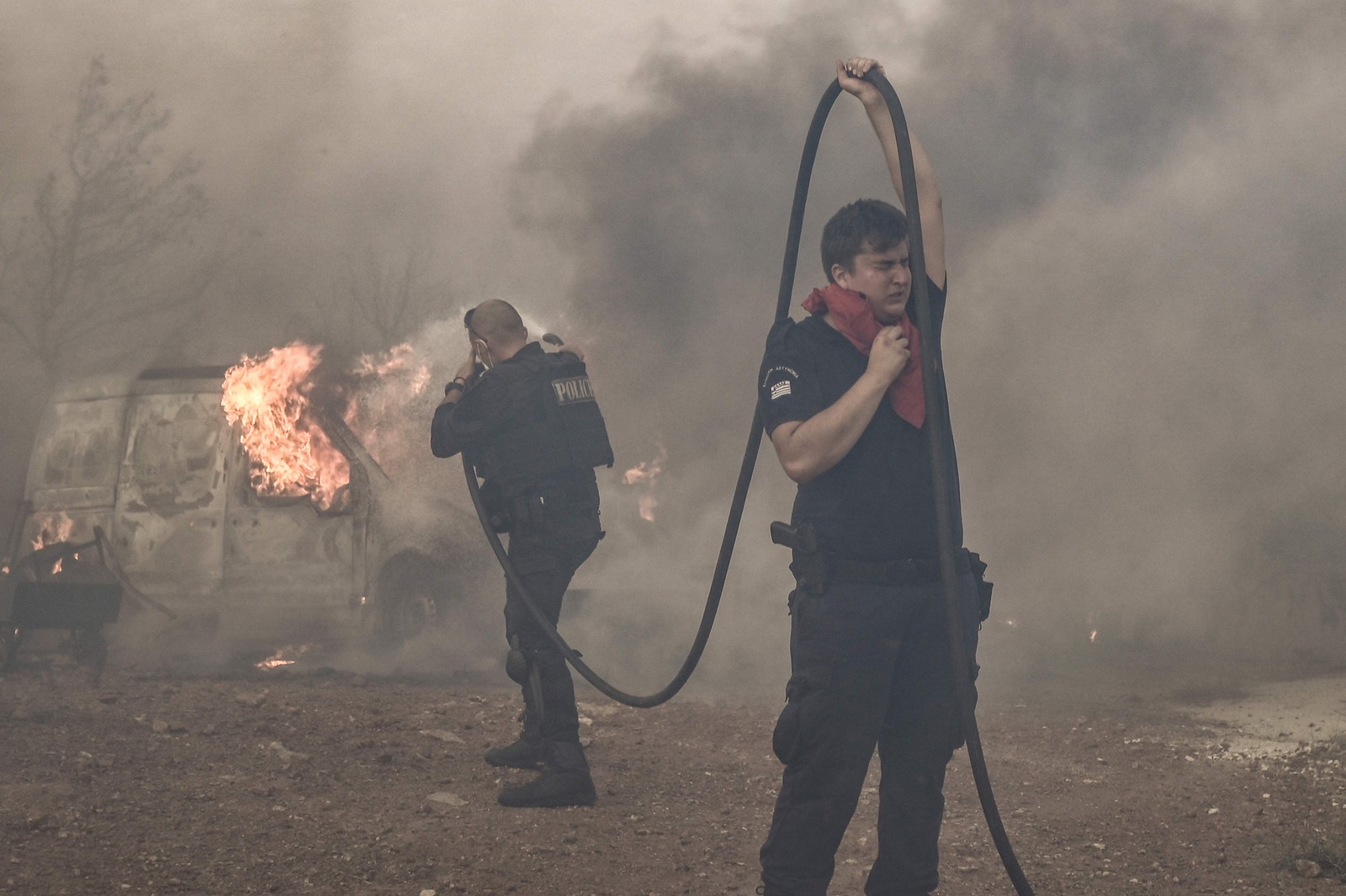 Policiais combatem o incêndio na área de Lagonisi, a cerca de 35km de Atenas. A polícia grega prendeu um homem suspeito de iniciar um incêndio florestal em andamento perto de Atenas, alimentado pela onda de calor e ventos fortes, disseram os bombeiros. — Foto: Spyros BAKALIS / AFP