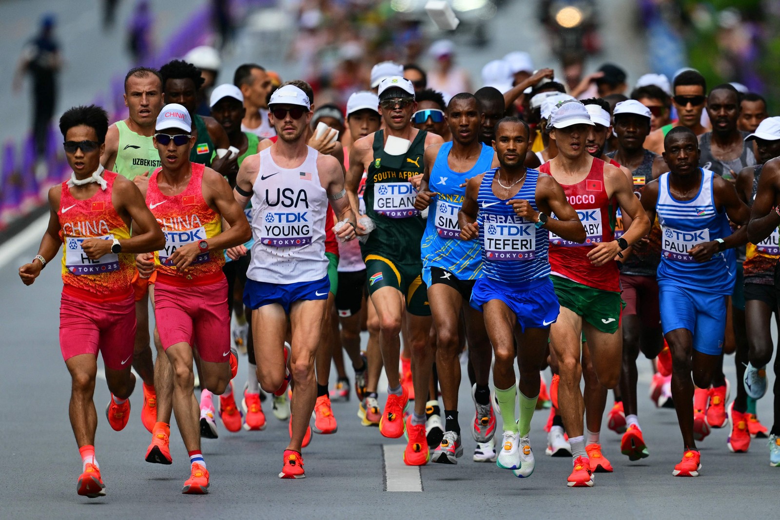 Alphonce Felix Simbu (de azul) aparece no pelotão, durante a prova da maratona de Tóquio